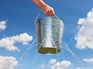 Man Holding Leaking Bucket --- Image by © Paul Hardy/Corbis